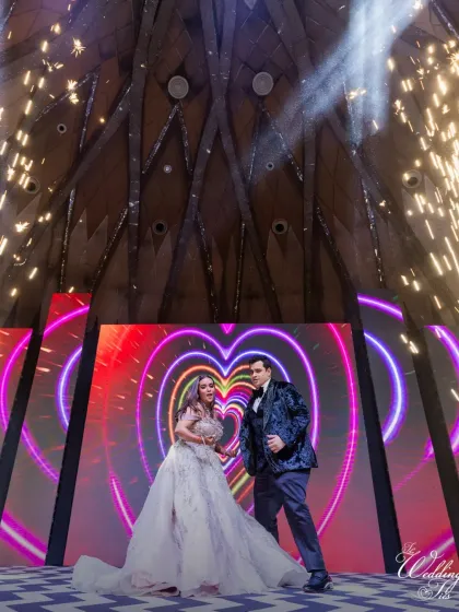 A fun and energetic pose from the couple's Sangeet dance, with a heart-themed graphic on the screen behind them. We customize visuals to match the mood of each performance.