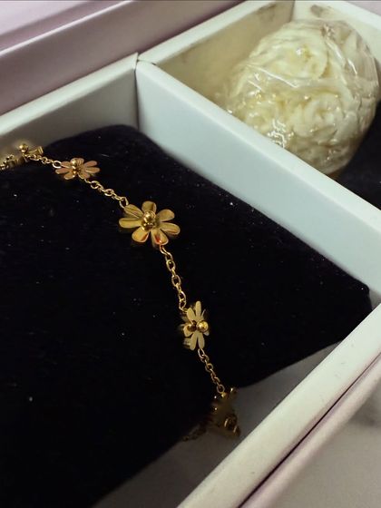 An unboxing shot of the Palmonas flower anklet, resting in its elegant gift box, creating a sense of love and anticipation.