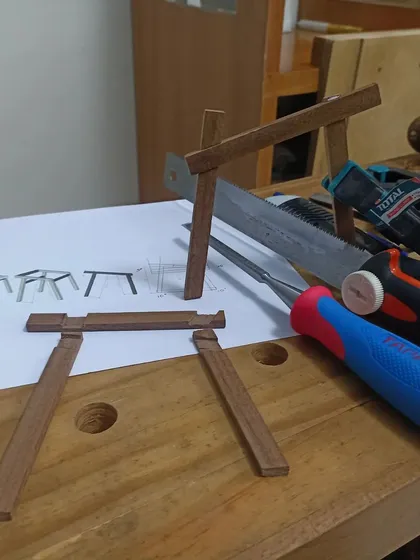 The components of the miniature chair model laid out with the design drawing. This process helps refine the construction steps for the actual build.