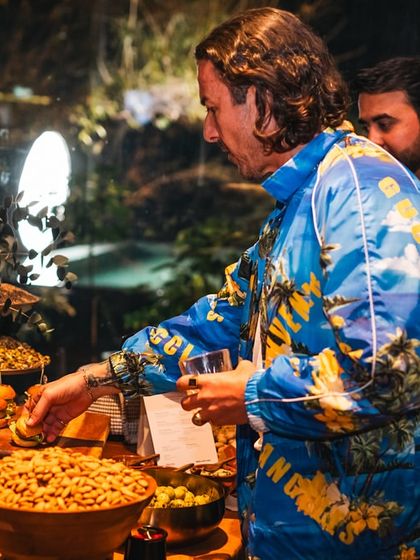 A guest helps himself to our bountiful grazing table during the Soho House event. The spread includes savory snacks, nuts, and mini burgers, offering something for every palate.