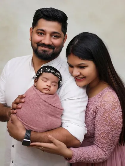 A classic first family portrait with a newborn. Our studio sessions provide a timeless look, focusing on the connection between new parents and their baby.