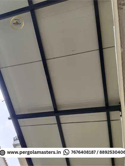 The underside of a completed puff sheet pergola, showing the clean white insulated panels and contrasting black metal frame. This roofing provides excellent heat insulation and a neat, modern finish.