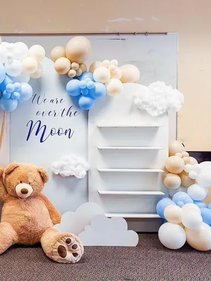 This setup includes a functional shelving unit integrated into the backdrop, perfect for displaying gifts or favors.