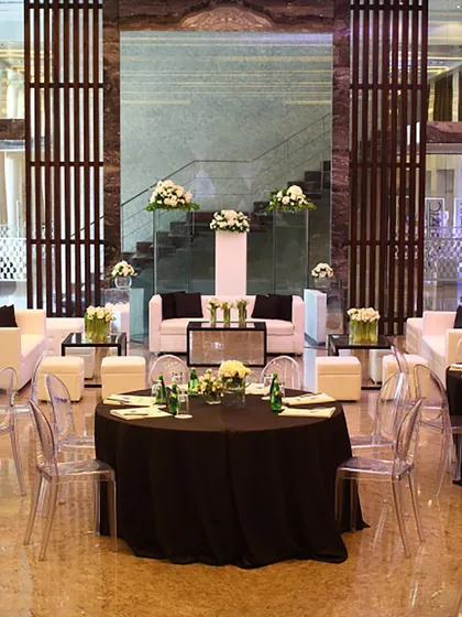 A chic and modern lounge setup for a corporate event, with black and white furniture and clean floral arrangements. We cater to all types of events, ensuring a sophisticated ambiance.