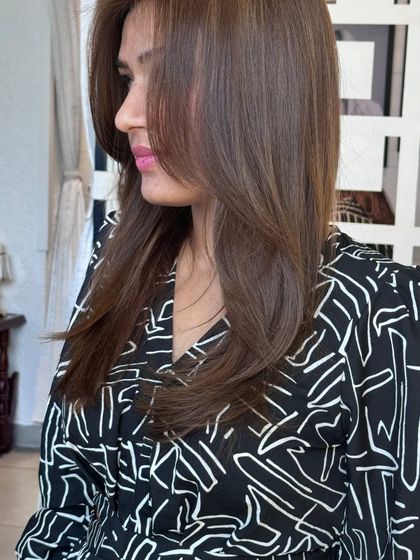 A side profile showcasing a beautiful brown hair color with face-framing layers. This style is perfect for highlighting facial features while maintaining a soft and elegant look.