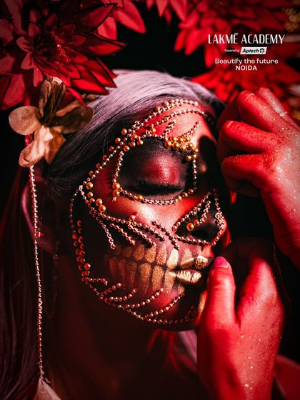 A close-up showing the application of gold bead detailing on the fantasy skull makeup, a technique that requires precision and patience.