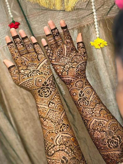 A close-up of the palms, showing the intricate floral and traditional patterns. The design is dense and full of beautiful details.