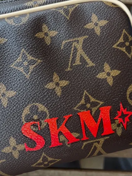 The other side of the Scrooge McDuck pouch, personalized with the client's initials "SKM" in a bold red font.