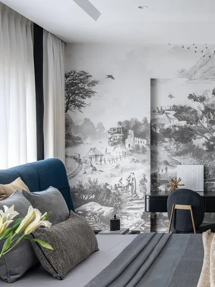 The master bedroom in the Evelyn penthouse features a stunning black-and-white landscape mural that wraps around the room. The custom blue bed with its high, curved headboard adds a bold statement of color and form.