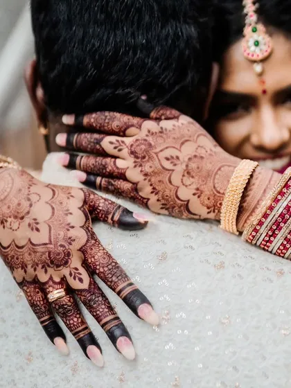 An intimate hug, where the bride's beautiful henna stain is a key part of the moment.