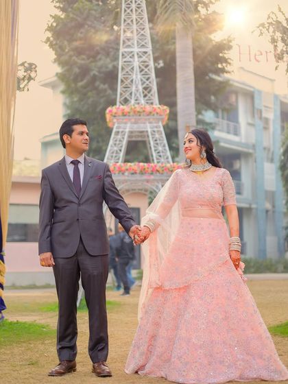 A romantic shot of the couple during their pre-wedding shoot, with an Eiffel Tower replica and beautiful backlighting.