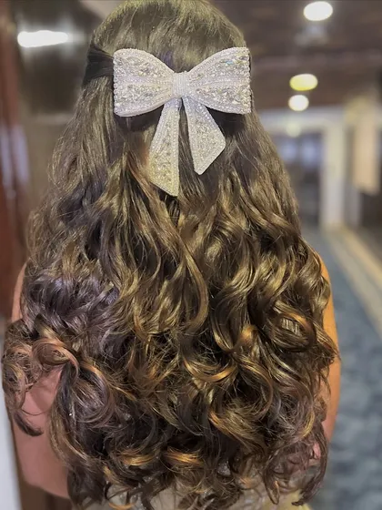 A back view of the bow hairstyle, showing the beautiful curls and the statement accessory.
