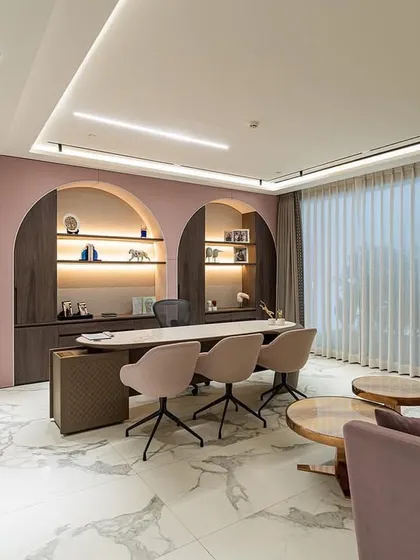 A wider view of the executive office, showcasing the balance between the powerful desk area and the comfortable seating nook. The dusty rose color palette and soft materials create a welcoming environment that reflects both legacy and feminine strength.
