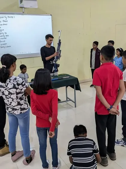 I always begin my workshops with a thorough safety briefing. Here, I am demonstrating the parts of an air rifle to a group of young learners before we head to the shooting line.