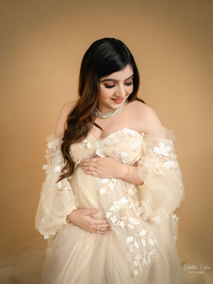 A seated pose, looking down at your bump, is both comfortable and elegant. It allows for a beautiful, intimate portrait that focuses on your connection with your baby.