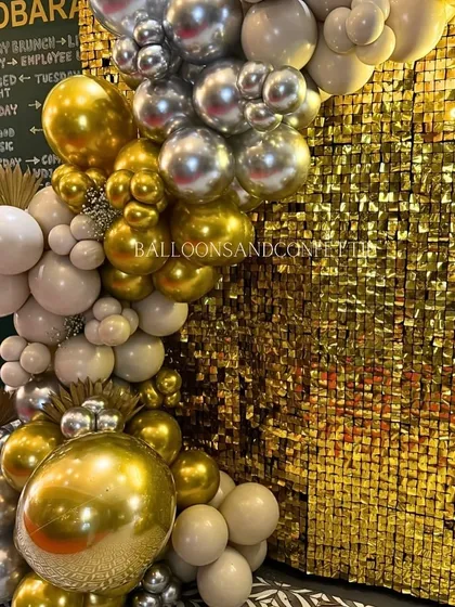 A detailed view of the organic balloon garland against the gold shimmer wall. I love mixing chrome and matte balloons to create depth and texture.