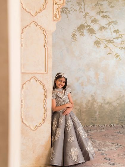 The structured skirt and embellished blouse create a sophisticated silhouette, perfect for a wedding reception.