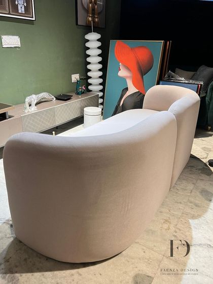 Different angles of a beautifully curved sofa in a neutral beige fabric. The soft, rounded forms and assortment of cylindrical and round cushions create an exceptionally comfortable and stylish seating experience.