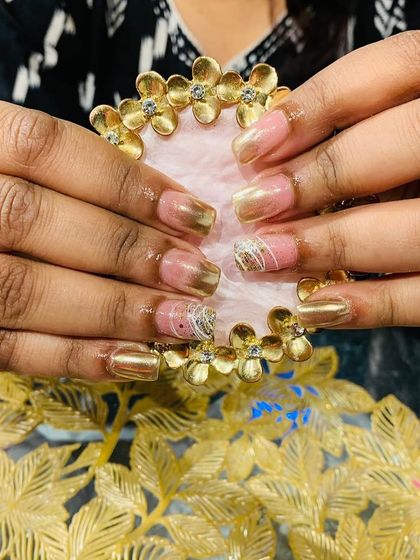 A sophisticated design featuring gold chrome, a soft pink base, and accent nails with intricate white thread work.
