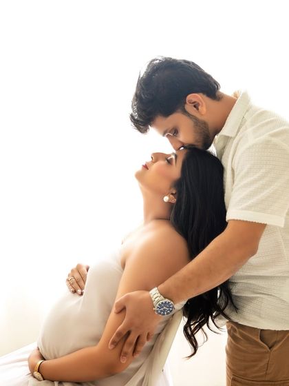 A tender forehead kiss is a simple yet powerful pose that conveys so much love and care. It's a favorite in my couple maternity sessions.