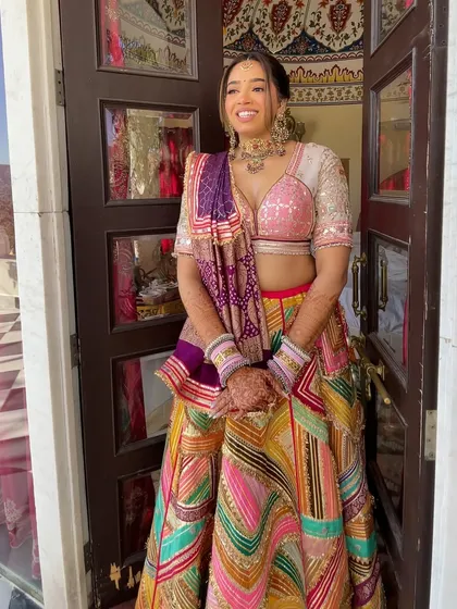 The bride in her colorful Mehndi outfit. The braided hairstyle keeps her hair neatly off her shoulders, which is practical for the ceremony.