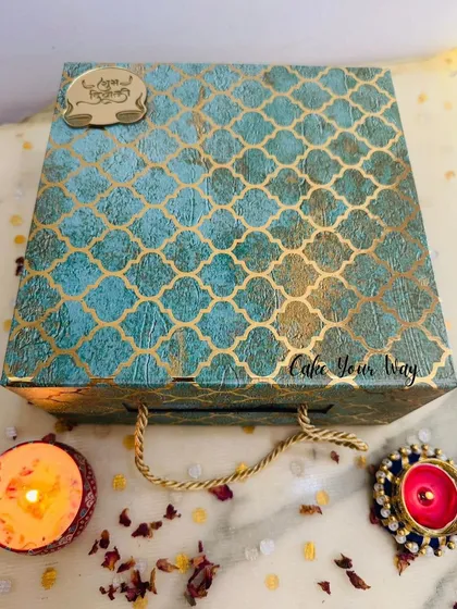 The stunning turquoise and gold patterned box for the 'Swaad-e-Diwali' hamper. It comes with a rope handle, making it a truly premium gift.