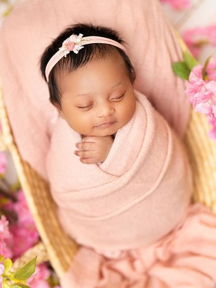 This newborn is nestled in a basket, surrounded by beautiful pink blossoms. I love incorporating floral elements to add a touch of nature and softness to the portraits.