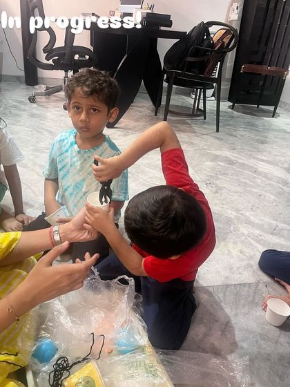 We took a leap into the world of gravity. Here, a child is using a weighing scale during our parachute-making experiment, learning about weight and air resistance in a hands-on way.