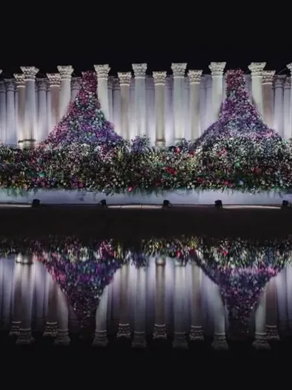 We don't just build structures; we create art. For this reception, we installed 22-foot Roman pillars and set them against a water body to create this stunning reflection. It's about achieving that unconventional balance between simple, grand, and dramatic.