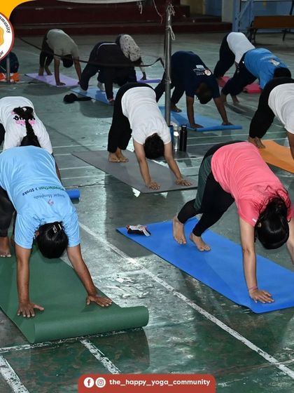 Students in Parvatasana (Downward-Facing Dog) during the 108 Surya Namaskara challenge. The sight of everyone moving together is a powerful symbol of unity.