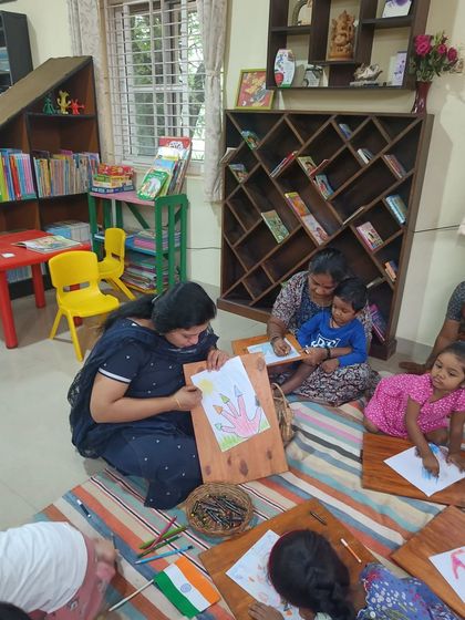 A storyteller demonstrates a drawing technique to help the children create their own illustrations.