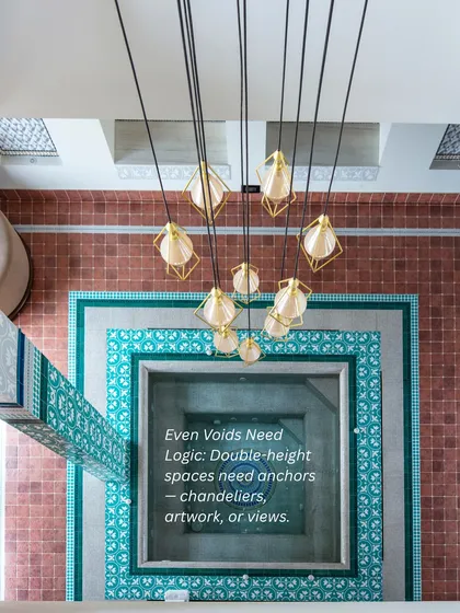 Even empty spaces need logic. Double-height voids are anchored with statement chandeliers, artwork, or breathtaking views to give them purpose and prevent them from feeling soulless.