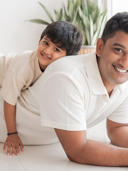 A playful moment between a father and son during a family photoshoot.