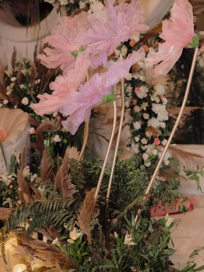 A detail shot of the whimsical fabric flowers and pampas grass arrangements that added a soft, dreamy texture to the ring ceremony decor.