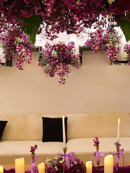 A view of the hanging floral installation over the sofa, which complements the main arch and makes the entire room feel like it's blooming.
