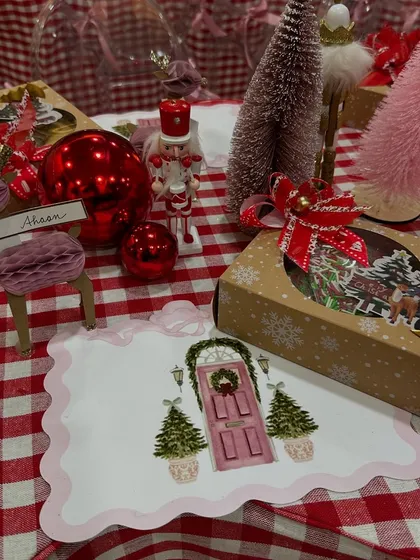 A festive detail from the Christmas party table, with personalized place cards, themed gift boxes, and miniature holiday decorations.