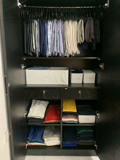 A full view of a well-organized men's wardrobe, showcasing a system that balances hanging clothes with neatly categorized shelf storage.
