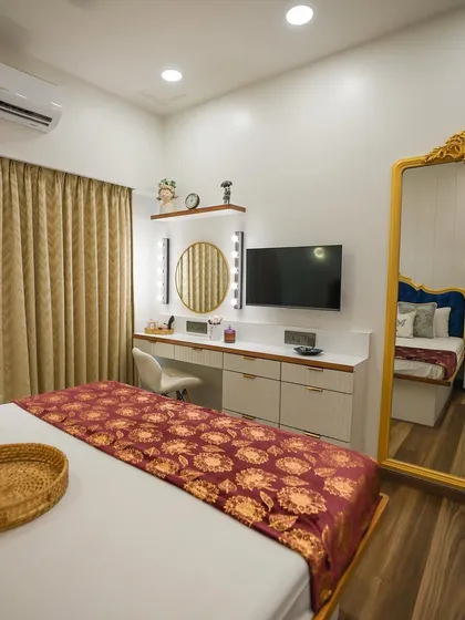 A wider view of the bedroom, capturing the relationship between the bed, the vanity unit, and the full-length mirror.