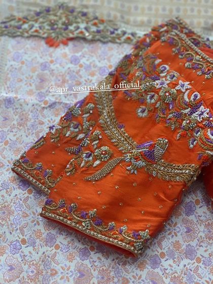An orange blouse with all-over bird and floral embroidery.