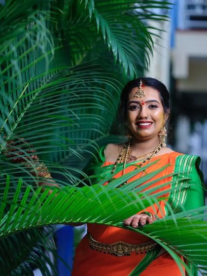 A lovely outdoor shot of Chandana. The natural light highlights the flawless finish of her makeup and the richness of her traditional attire.