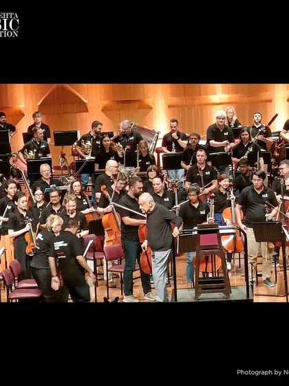 The orchestra takes a bow. A photograph capturing the full ensemble after a powerful performance, a testament to the collective effort and passion of every musician on stage.