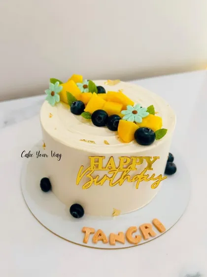 Sweet, simple, and stunning. A minimalist cake topped with fresh mangoes and blueberries.