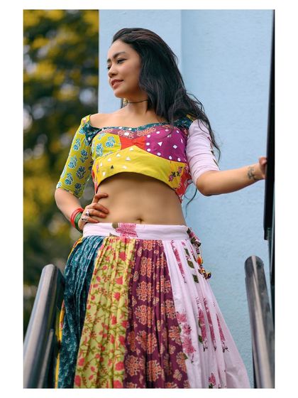 An outdoor shot of a vibrant, multi-colored patchwork lehenga-style outfit, capturing a folk-inspired, bohemian vibe.