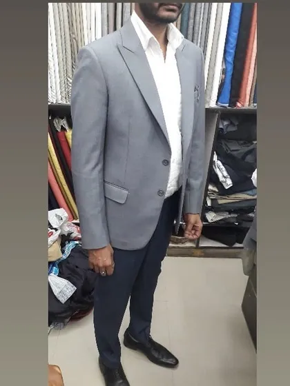 A client wearing a light grey blazer I tailored for him. It's paired with navy trousers for a classic smart casual look, ideal for office wear or social gatherings.