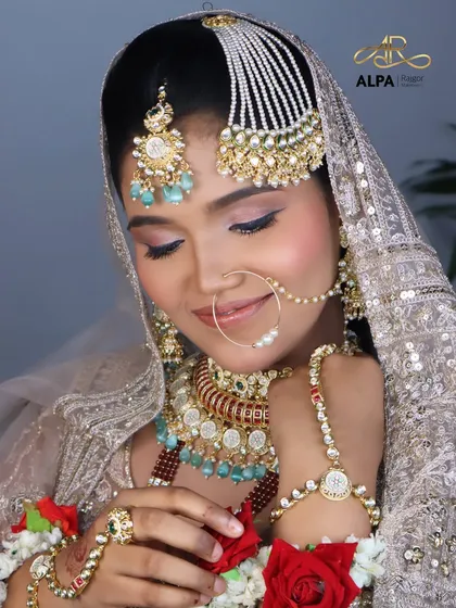 Adjusting the nose ring, this close-up shows the precision of the makeup application around the delicate jewelry.