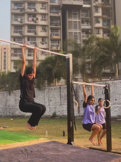 Our members practicing their hangs on the bars and rings during a beautiful morning at the park.