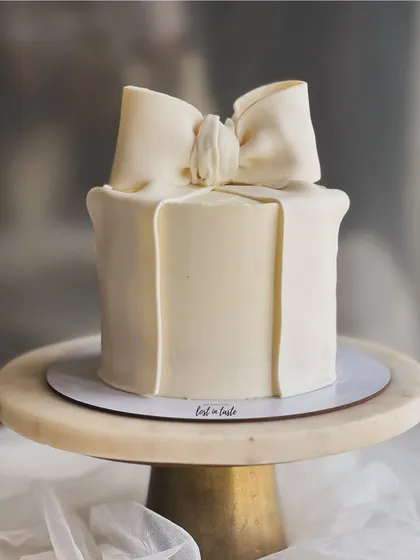 A clean and elegant bow cake, one of my most requested modern designs. The simplicity of the off-white buttercream and the perfectly sculpted bow makes it a statement piece for any occasion.