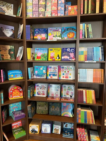 I've carefully curated our book collection to offer something for every young reader. The shelves are filled with colorful series, including a huge variety of Peppa Pig titles, activity books, and early readers.