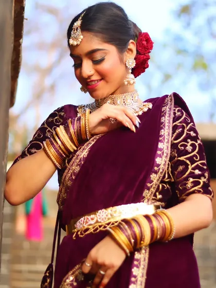 A close-up of the bride, her hands delicately posed, showing off her bangles and rings.