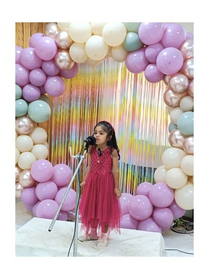 This young performer shines in a stunning pink dress, delivering her lines with poise.
